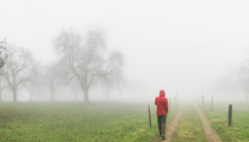 person walking on dirt road during an April rain shower